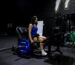 Woman seated on a GluteZone Hip Thrust Machine in a commercial gym, ready to train