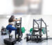 Woman training on a standing glute machine next to a plate loaded belt squat in a bright gym, part of a dedicated glute zone