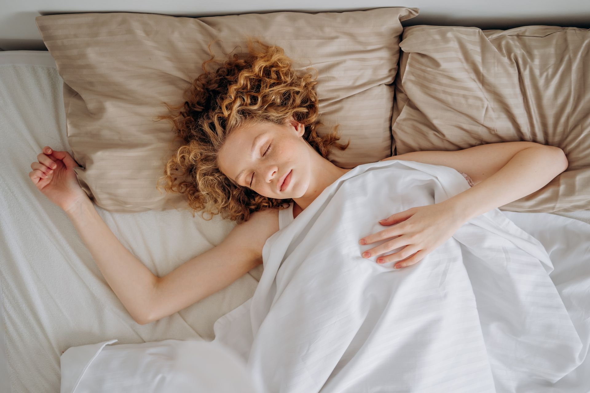 Sleep and Muscle Growth: What the Science Says 2 Woman sleeping soundly in bed, deep recovery sleep that supports muscle growth